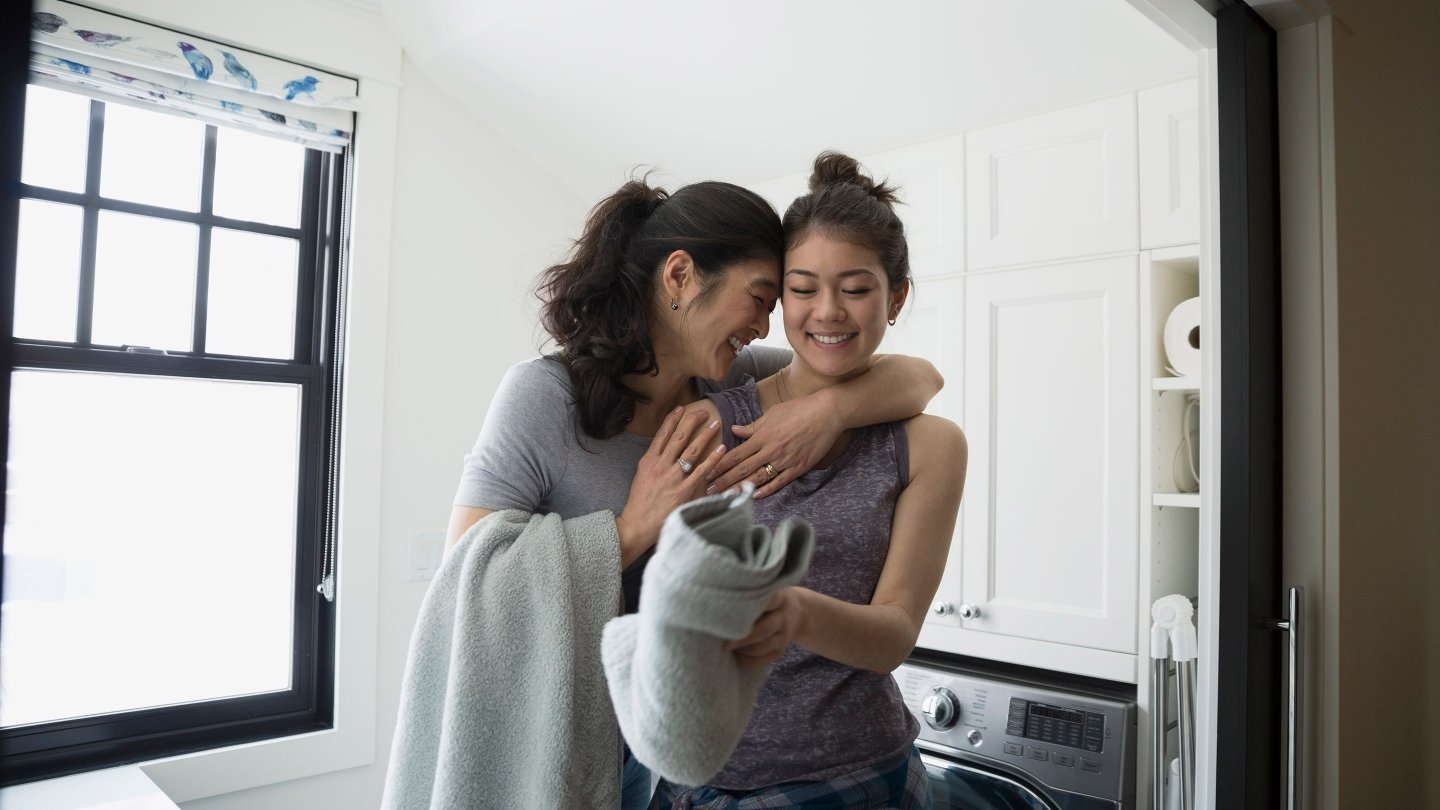 woman and daughter in a laundry room hugging