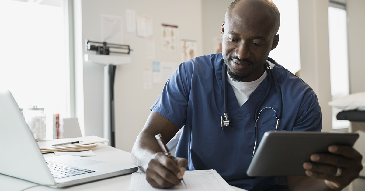Doctor in scrubs with digital tablet and clipboard