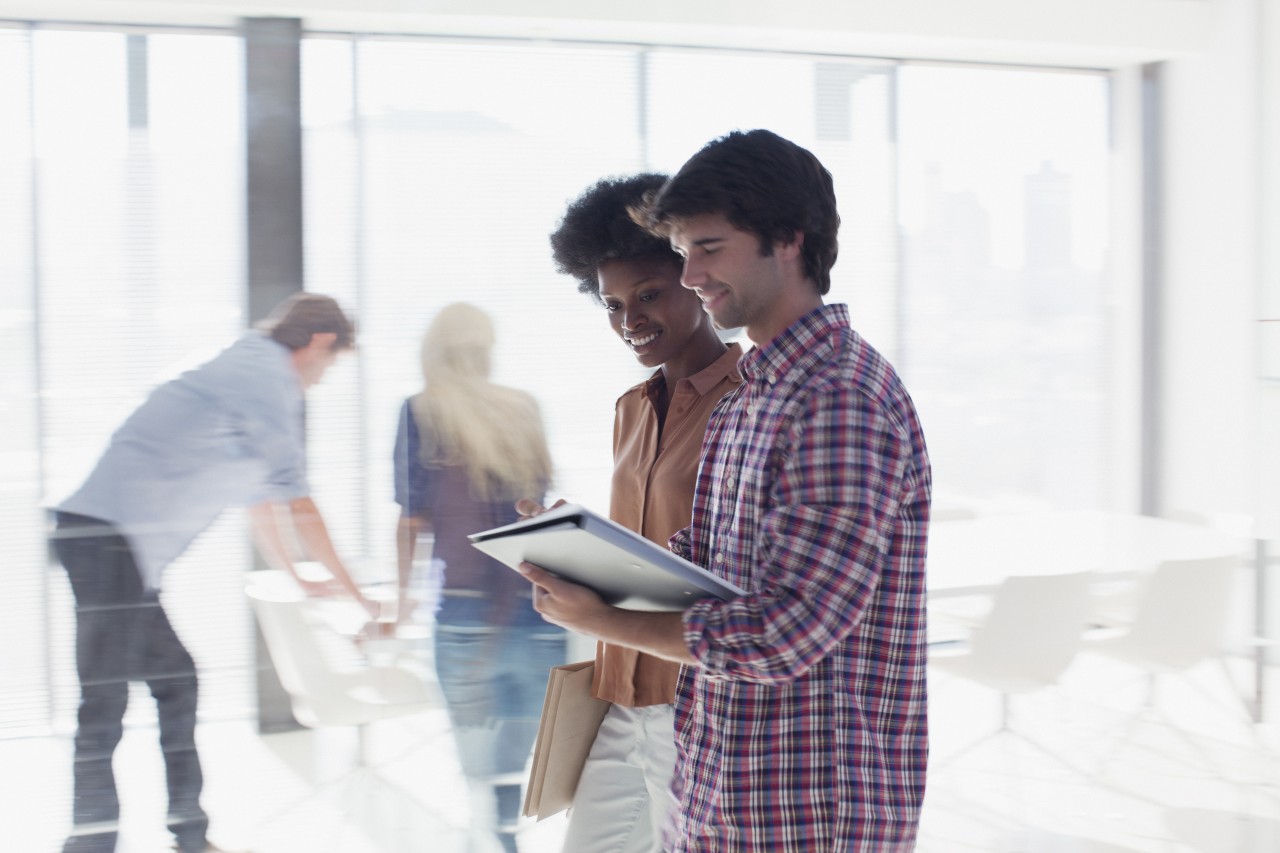 Smiling business people reviewing paperwork in office