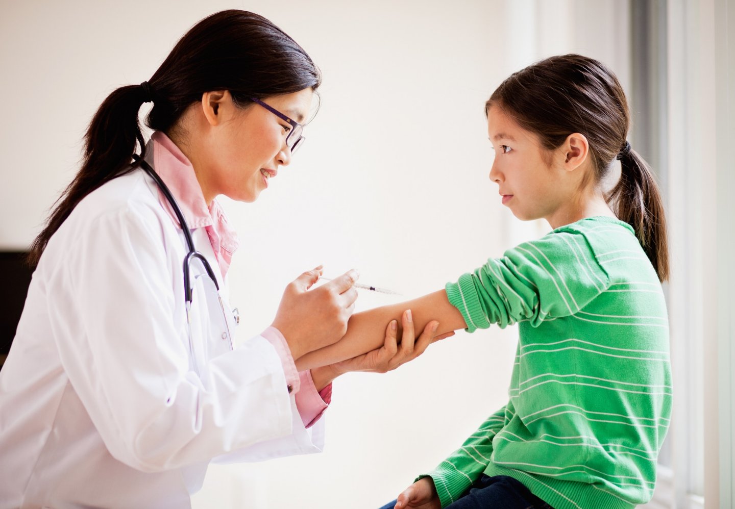 Doctor about to give a young patient an injection