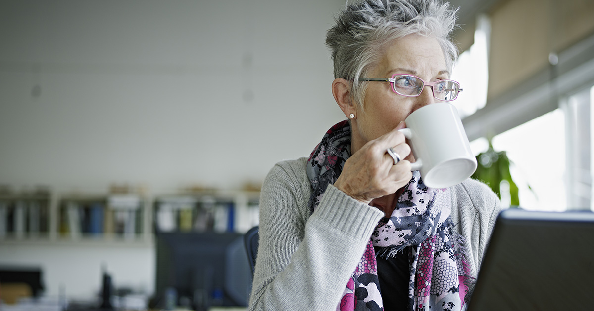 Businesswoman sitting in office drinking coffee