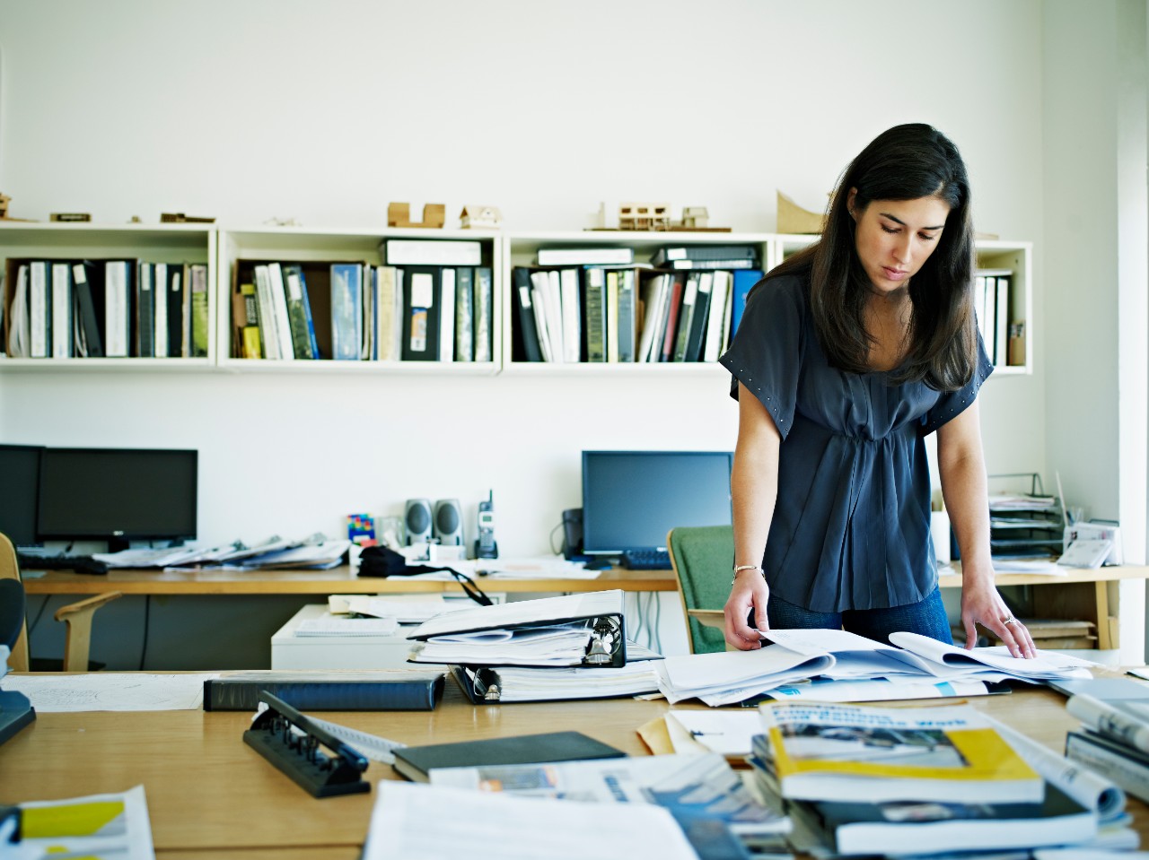 Female architect examining documents at desk