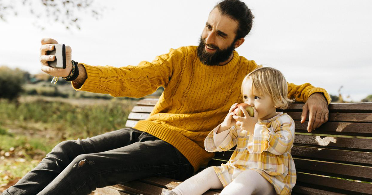 father and daughter sitting on a bench selfie