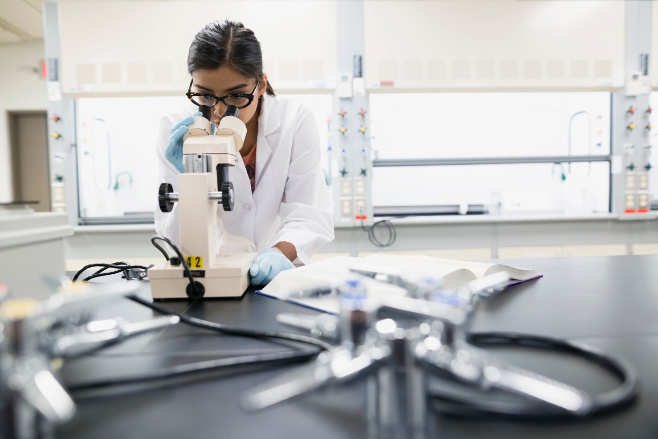 563876903 Scientist using microscope in laboratory