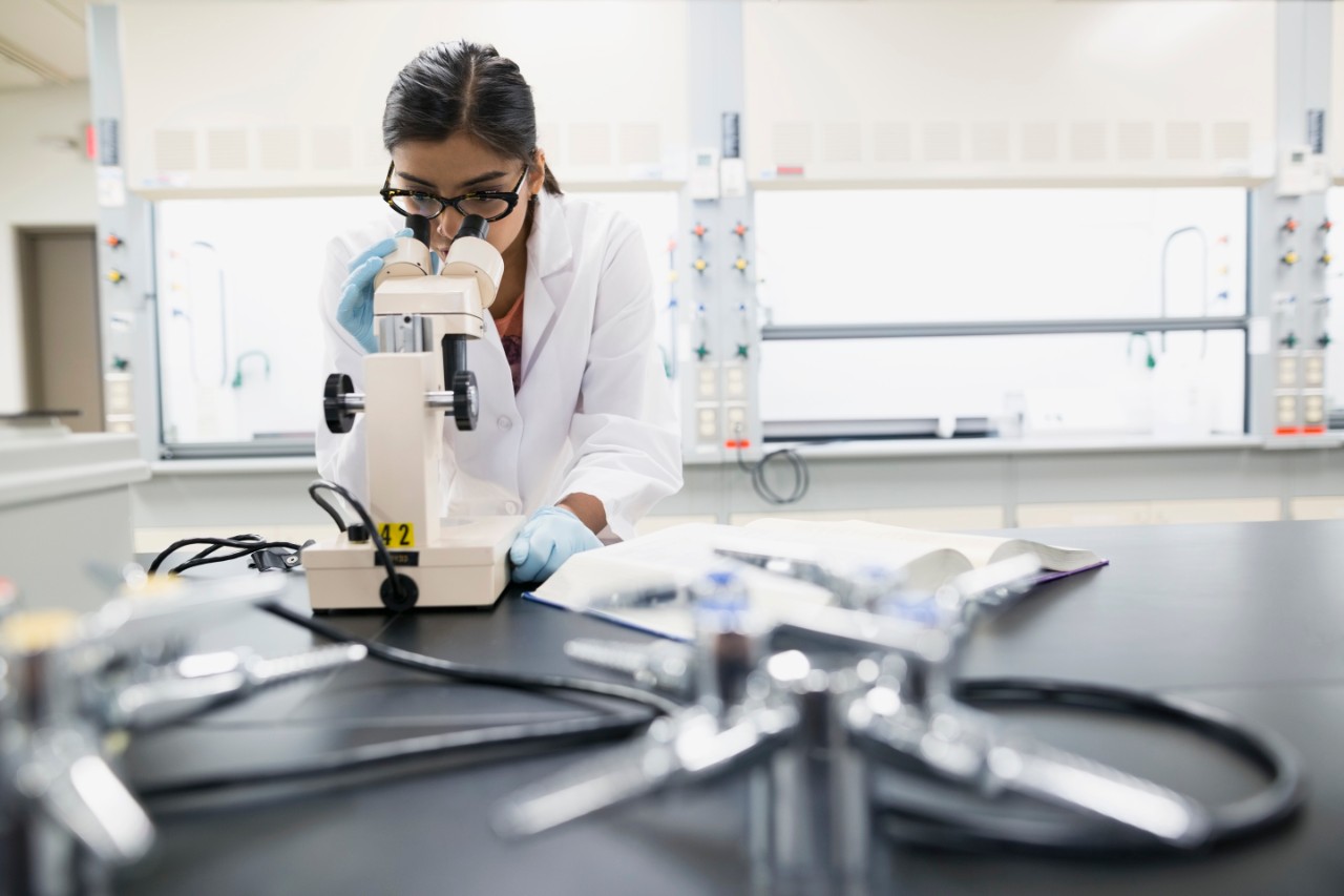 Scientist using microscope in laboratory