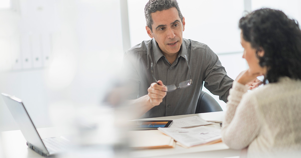 Businesspeople talking at desk in office, two people, meeting, conference