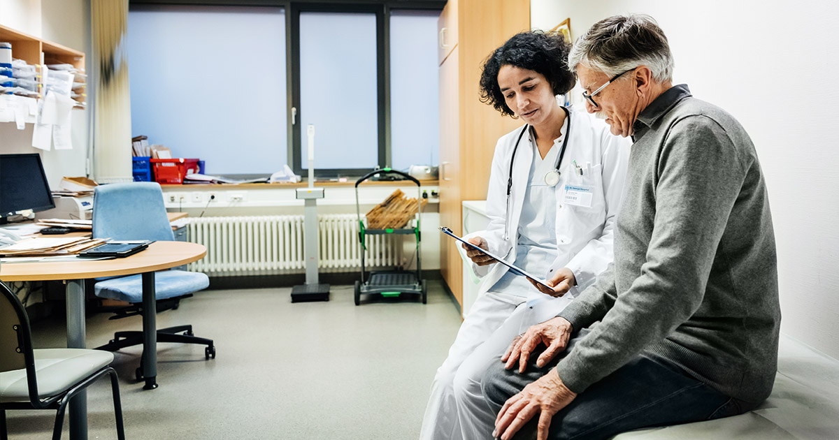 An elderly man talking to his doctor about some recent test results.