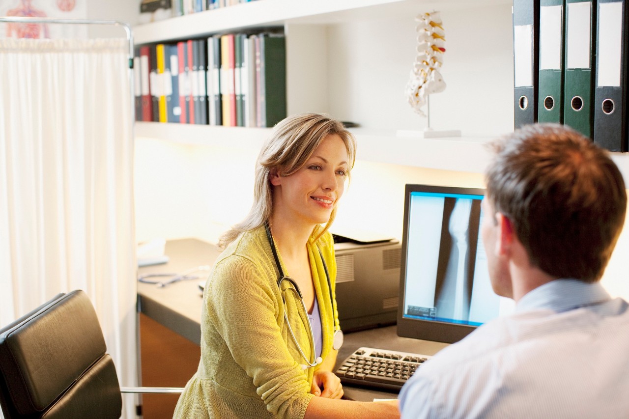 Doctor talking over x-ray with patient in doctors office