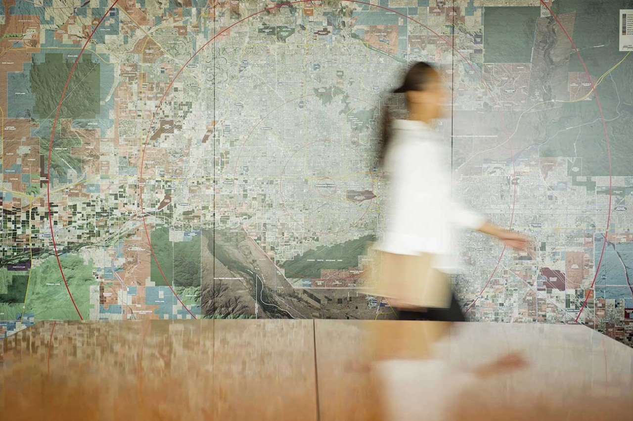 Mixed race businesswoman walking in conference table with map in background