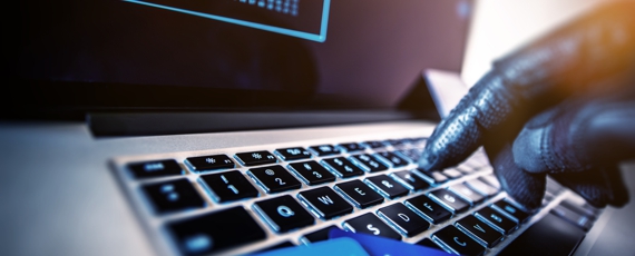 Credit Cards Theft Concept. Hacker with Credit Cards on His Laptop Using Them For Unauthorized Shopping. Unauthorized Payments