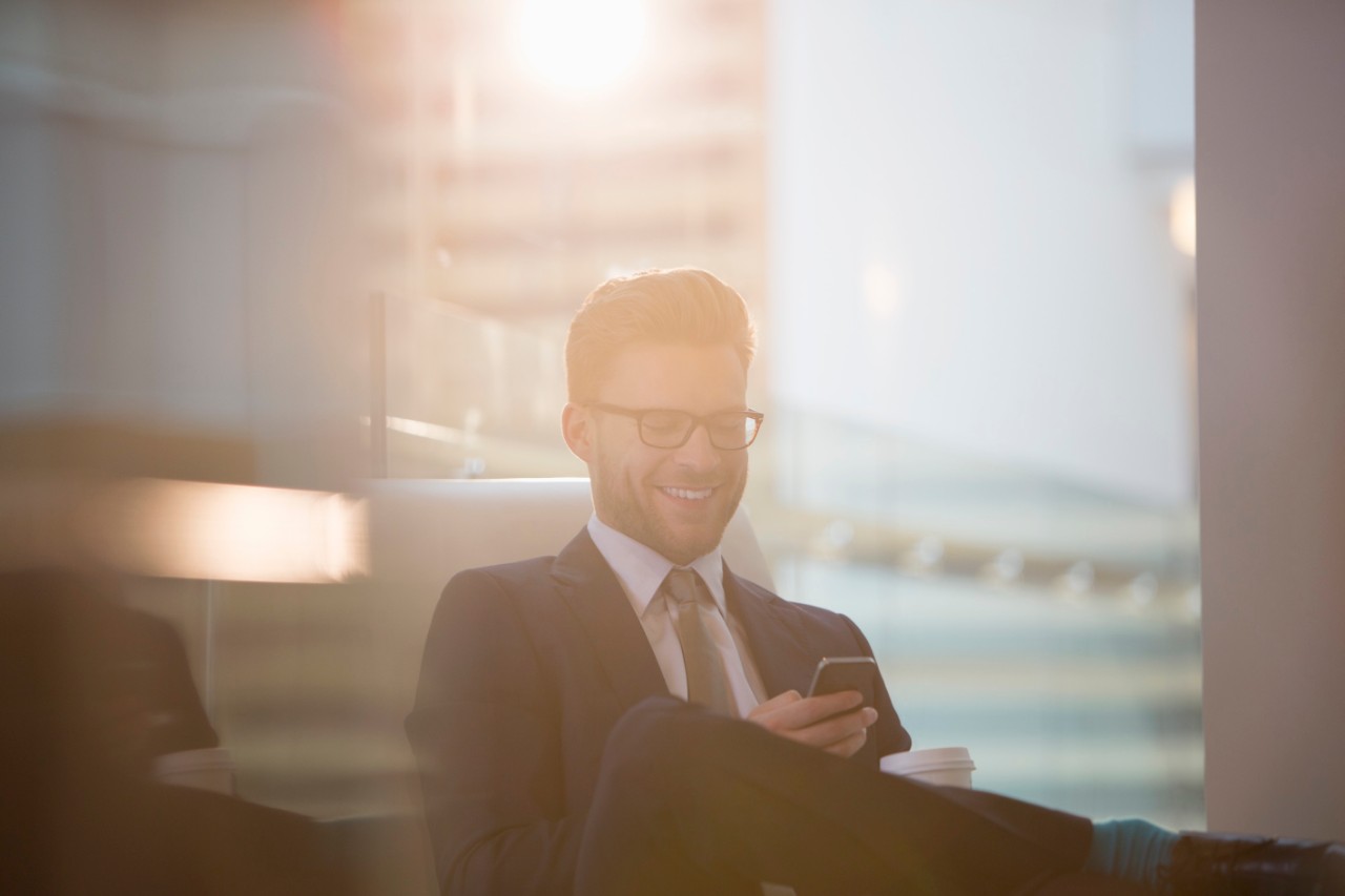 Businessman using cell phone in office