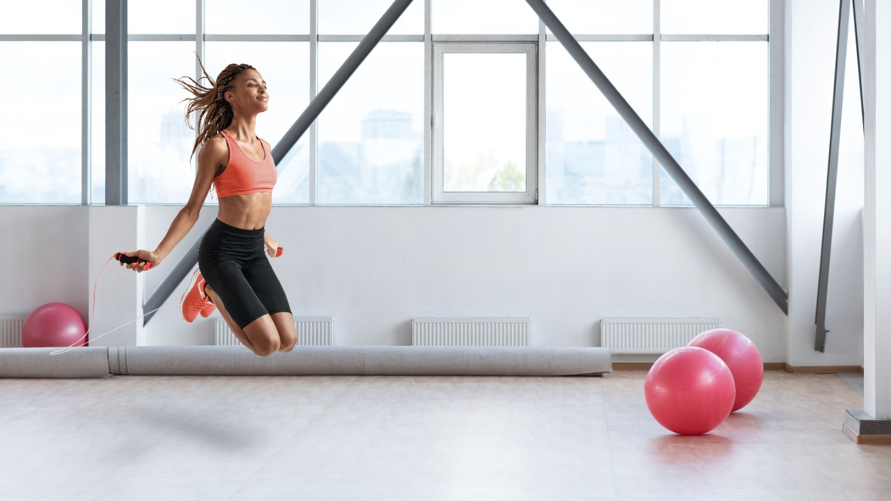 Young african woman skipping rope while exercising