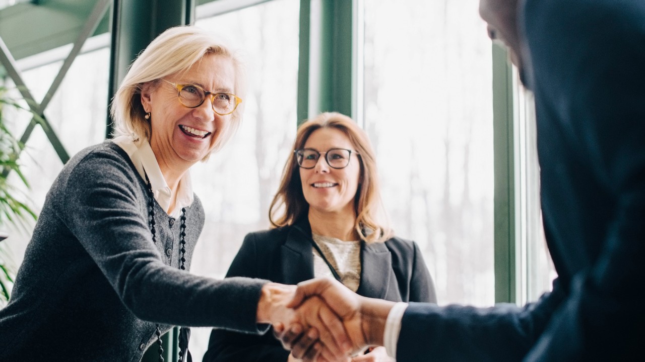 Two colleagues in business attire shaking hands