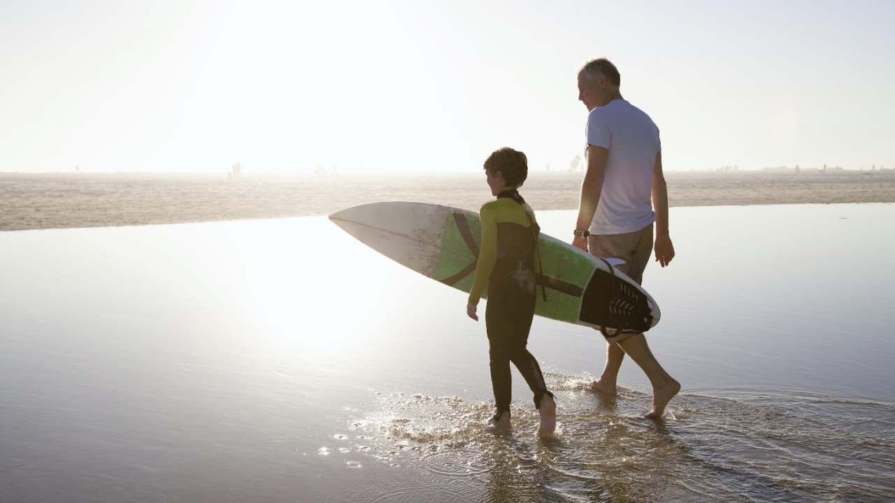 Man walking with child on beach