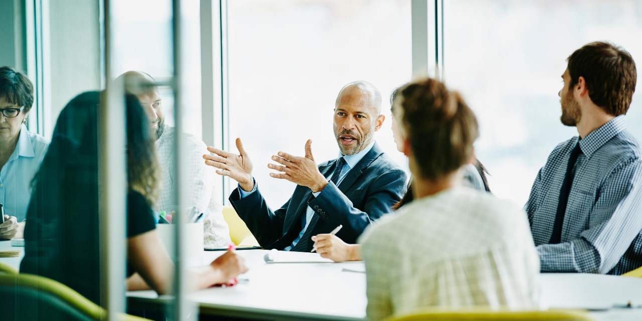 Mature businessman leading project meeting in office conference room