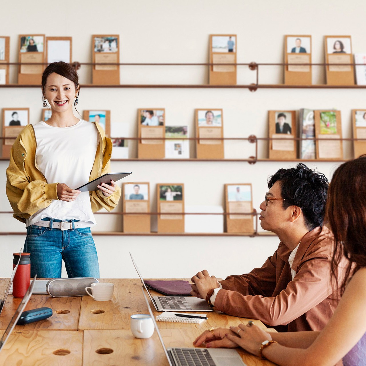 Group of young Japanese professionals working on laptop computers in a co-working space.