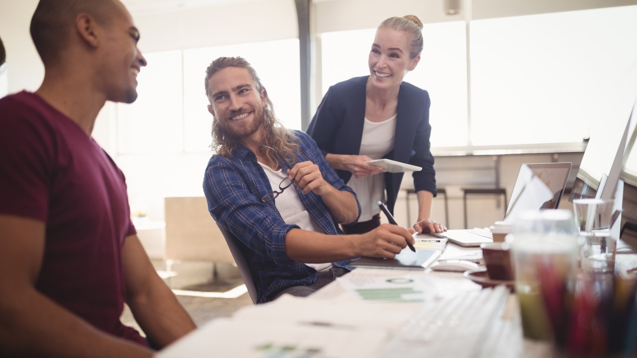 Happy business colleagues working together at creative office
