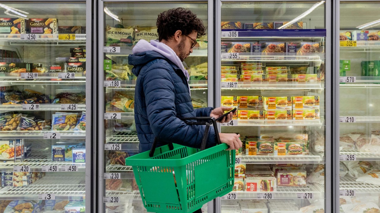 Hombre comprando en el supermercado frente a los refrigeradores