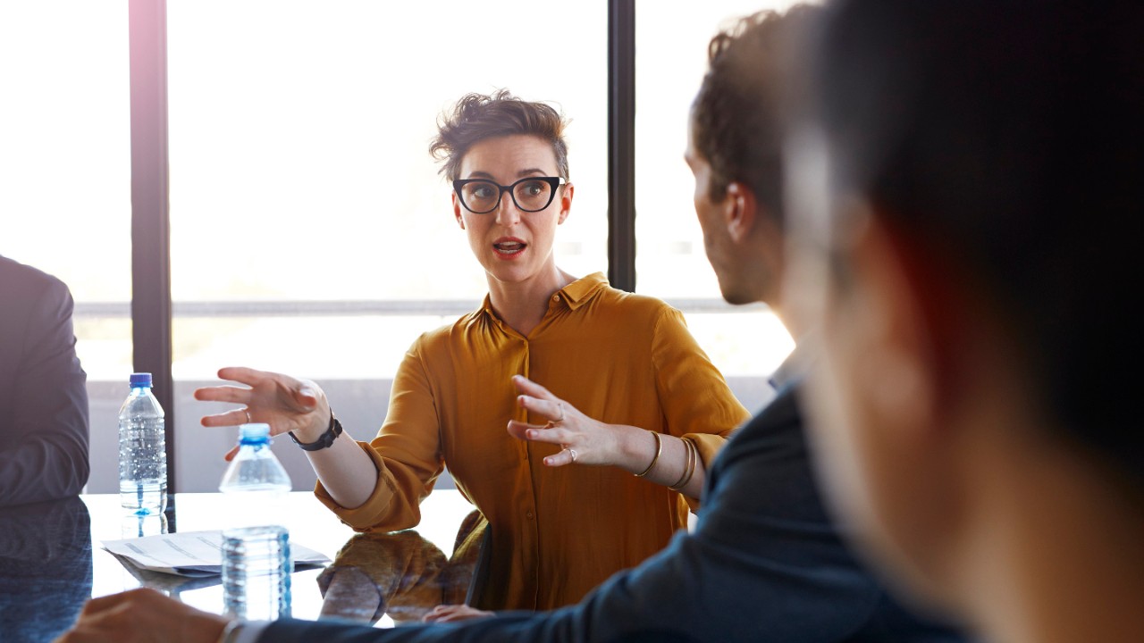 Businesswoman explaining to coworkers at meeting in conference room