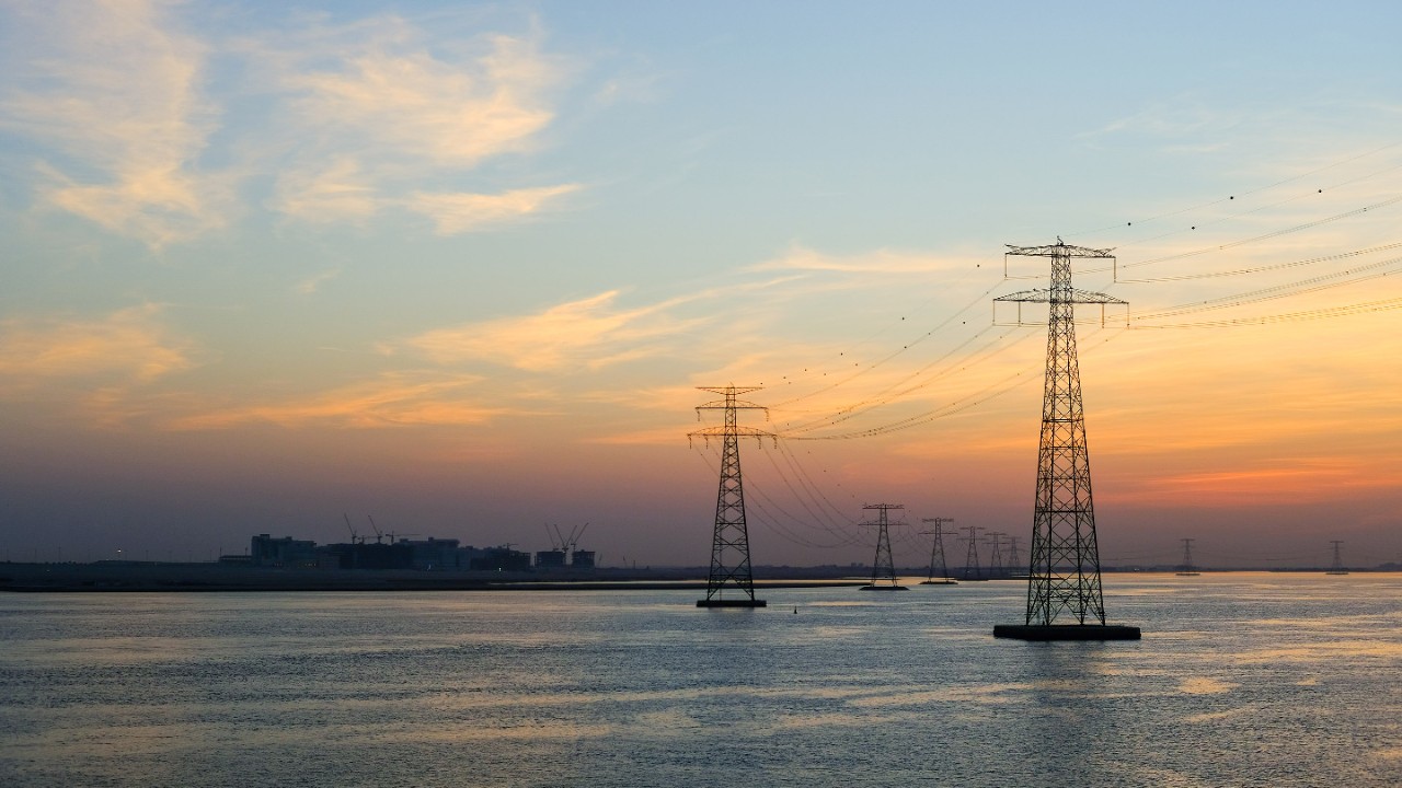 High voltage Electricty Power lines distributed through Ocean with amazing colourful clouds in background, Abu Dhabi, UAE