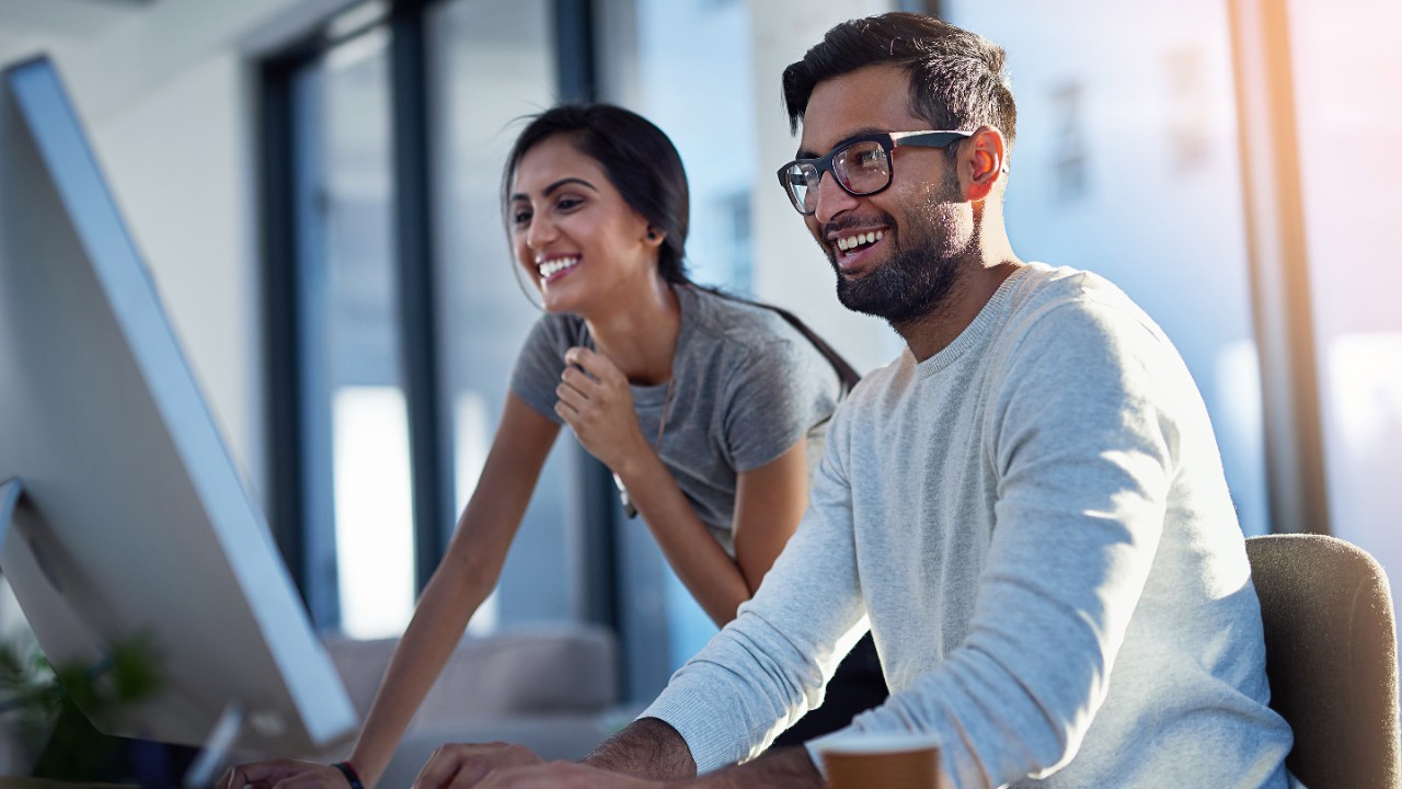 Shot of two young coworkers using a computer together at work