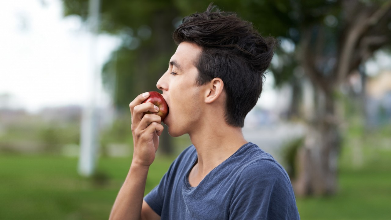 Young man taking a bite of an apple