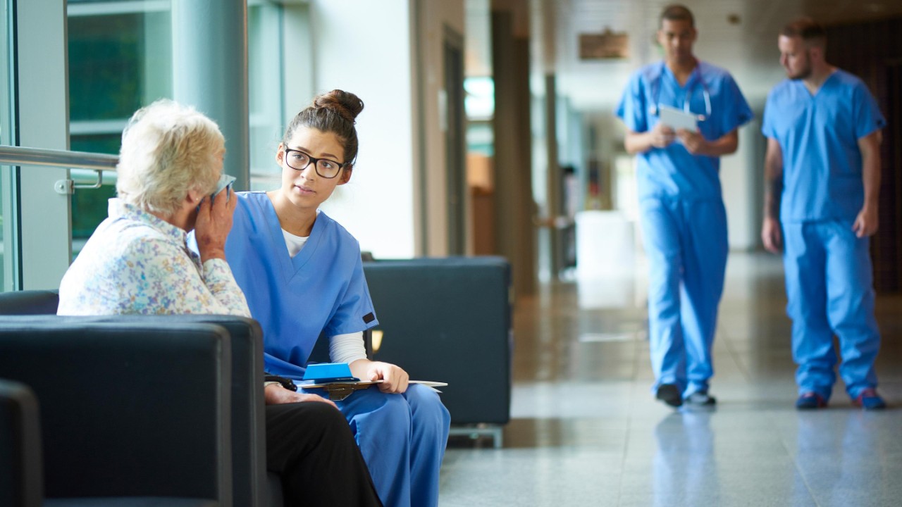 A female nurse consoles an upset patient
