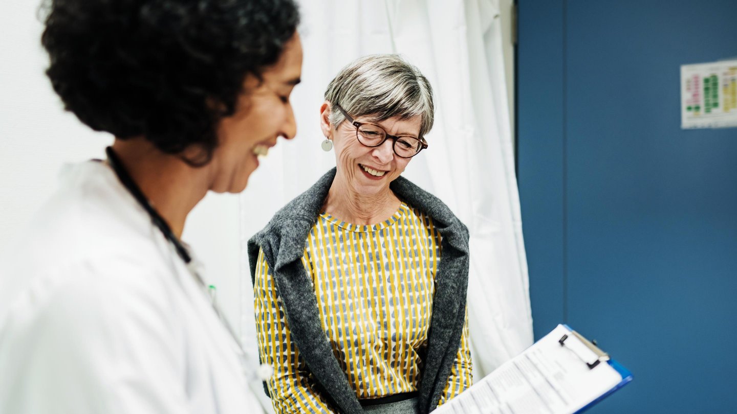  A clinical doctor going over some test results with an elderly patient at the hospital.