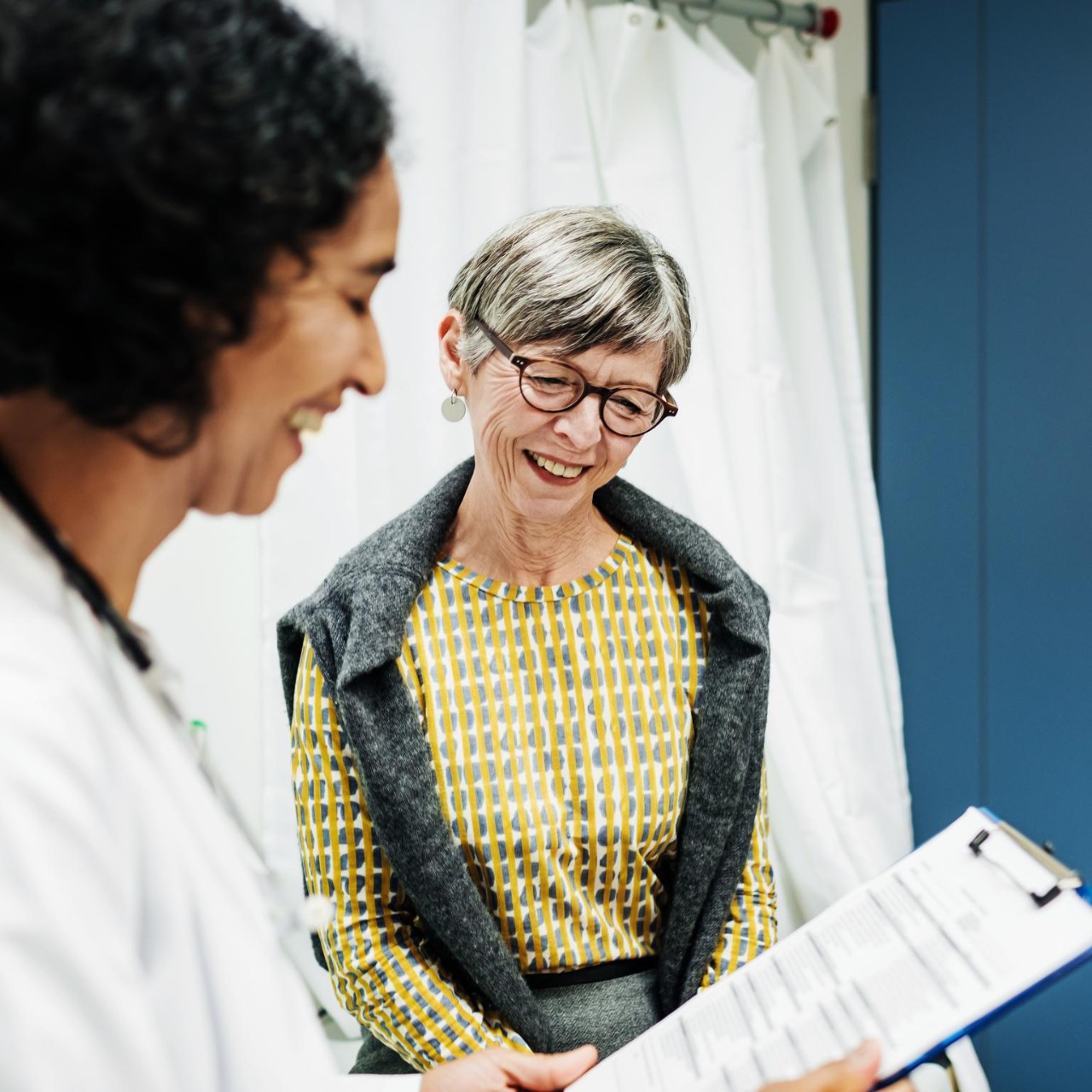 A clinical doctor going over some test results with an elderly patient at the hospital.