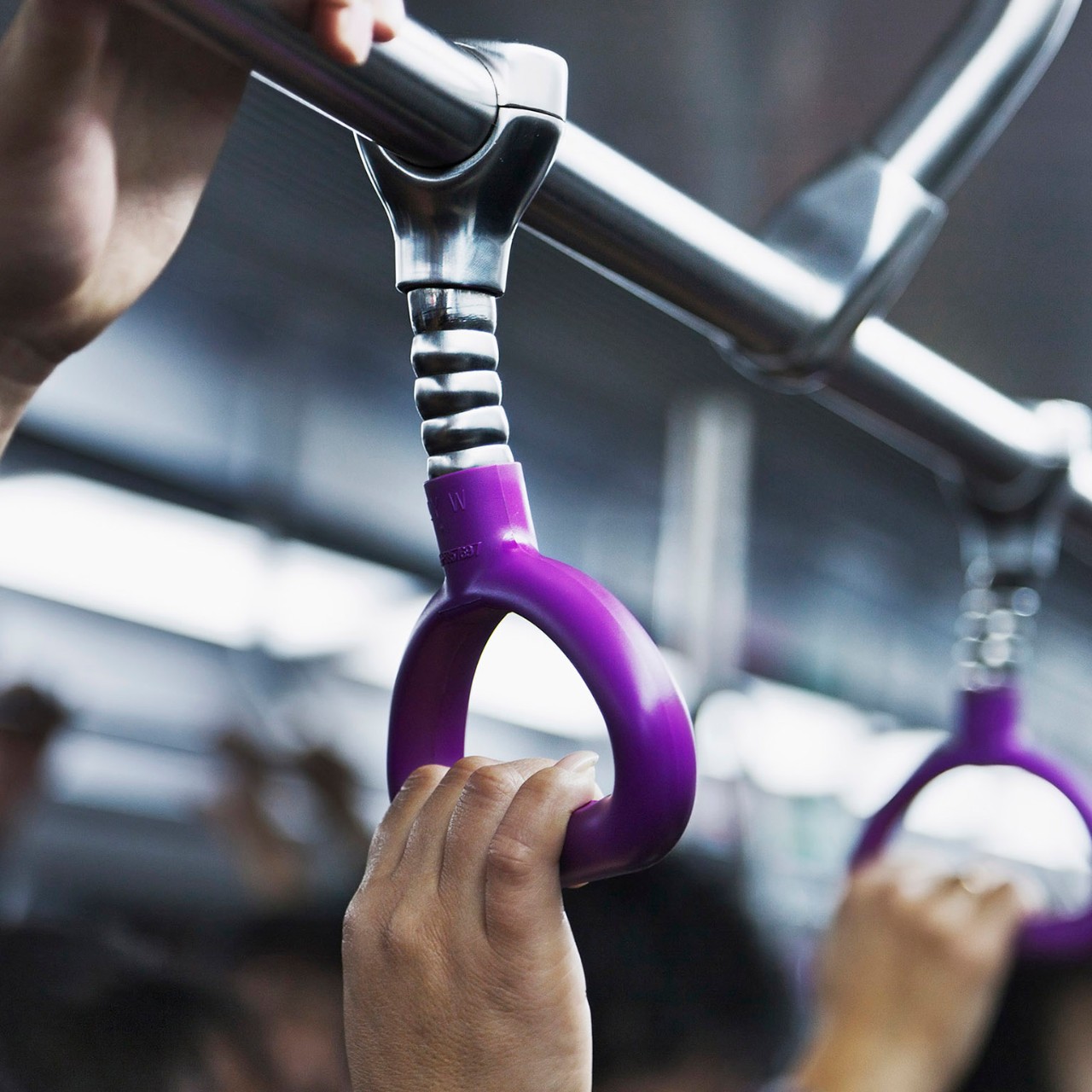 a hand holding hand rail on public transit