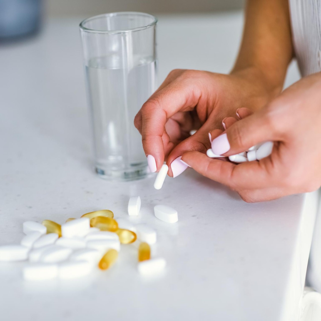 A young woman drinks pills