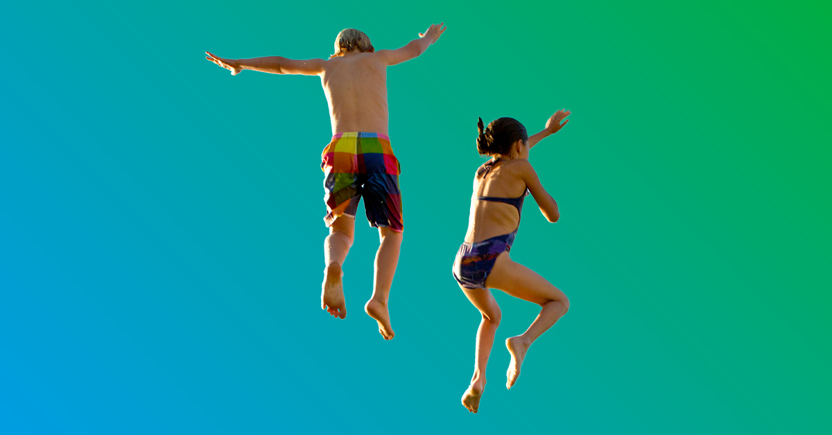 Young boy and girl in swimsuits jumping in air before plunge - blue to green gradient