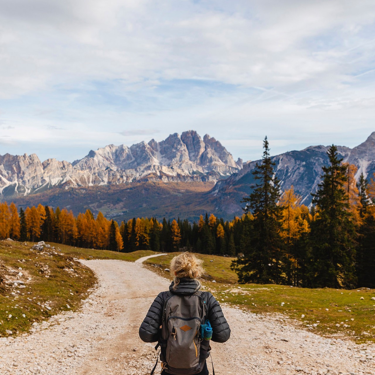 Rear view of female hiker hiking at Dolomites Alps, Cortina, Italy