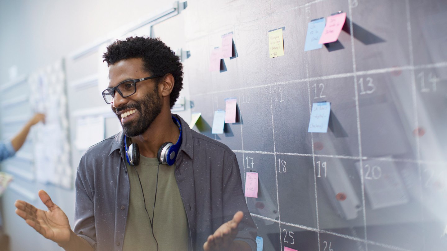  Happy, confident creative businessman planning, scheduling at calendar blackboard
