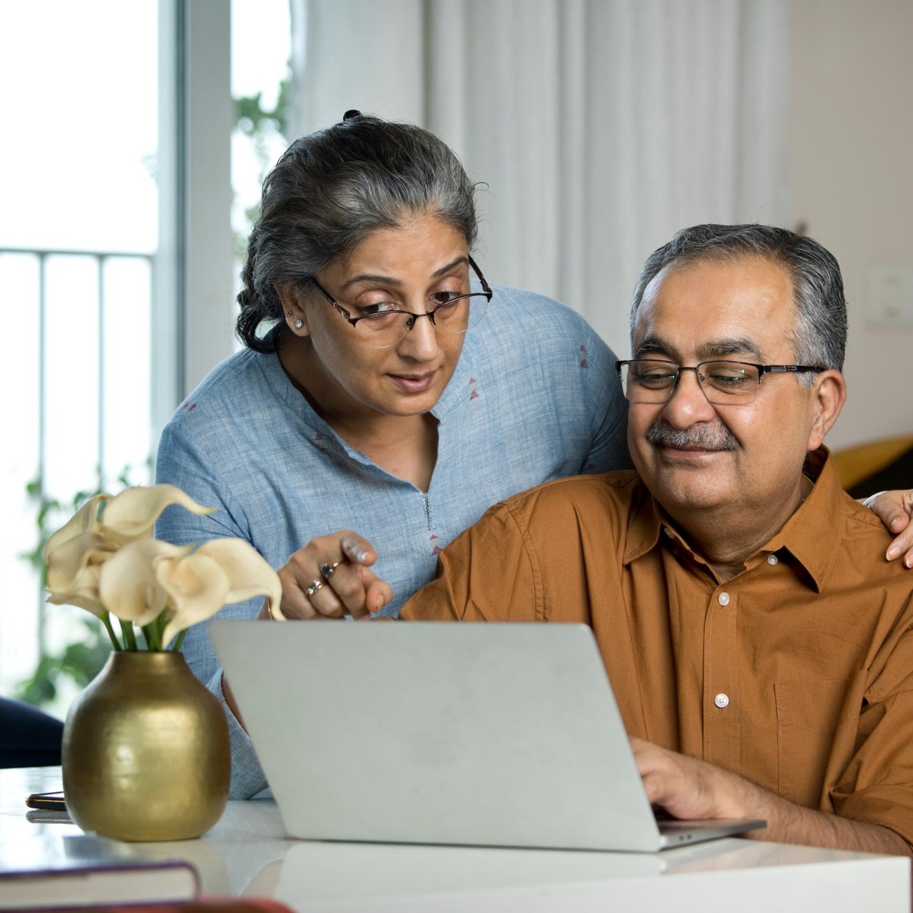 Senior couple using laptop while working on home budget