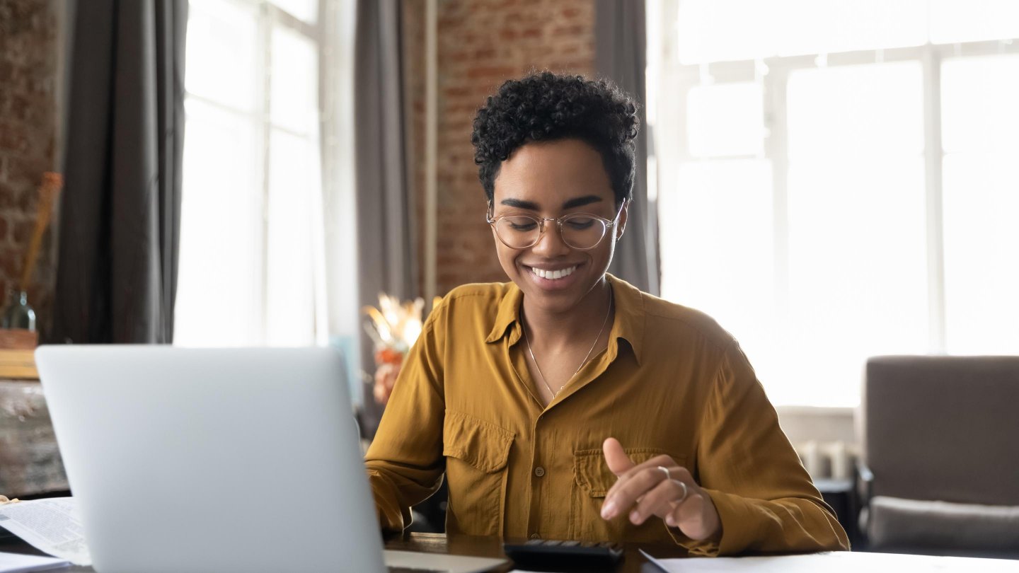 woman with laptop reviewing paperwork