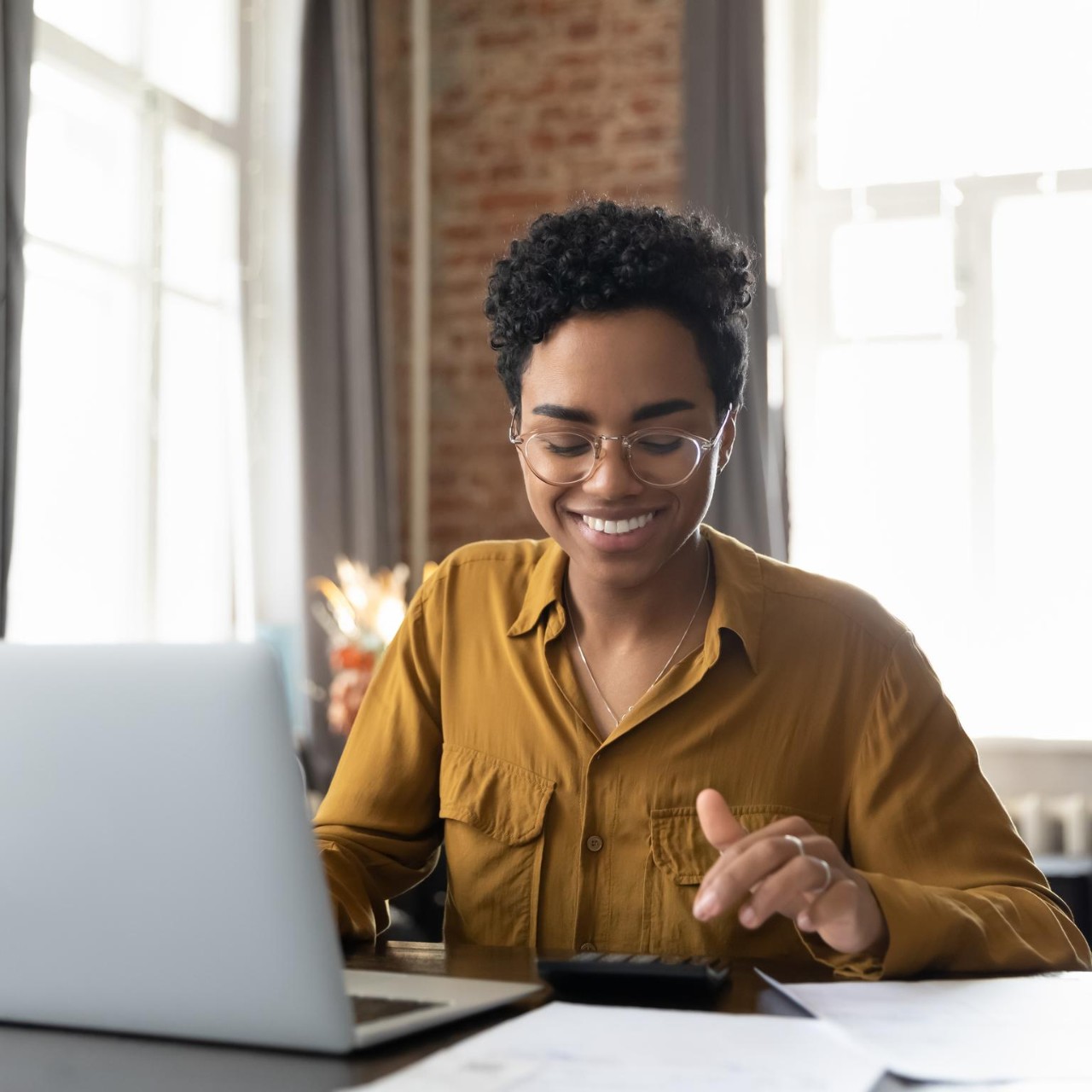 woman with laptop reviewing paperwork