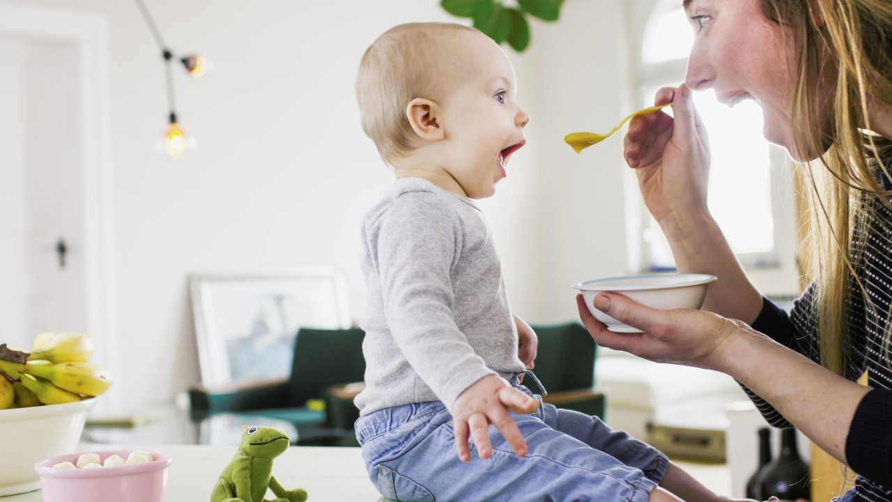 Mid adult woman feeding baby at home