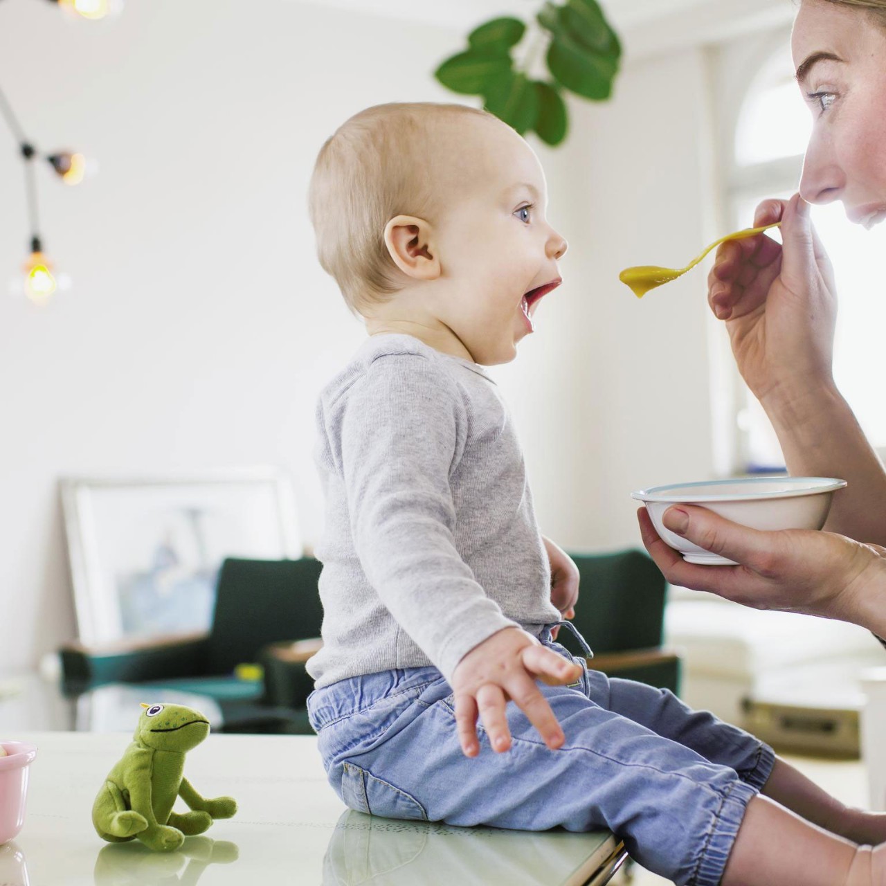 Mid adult woman feeding baby at home