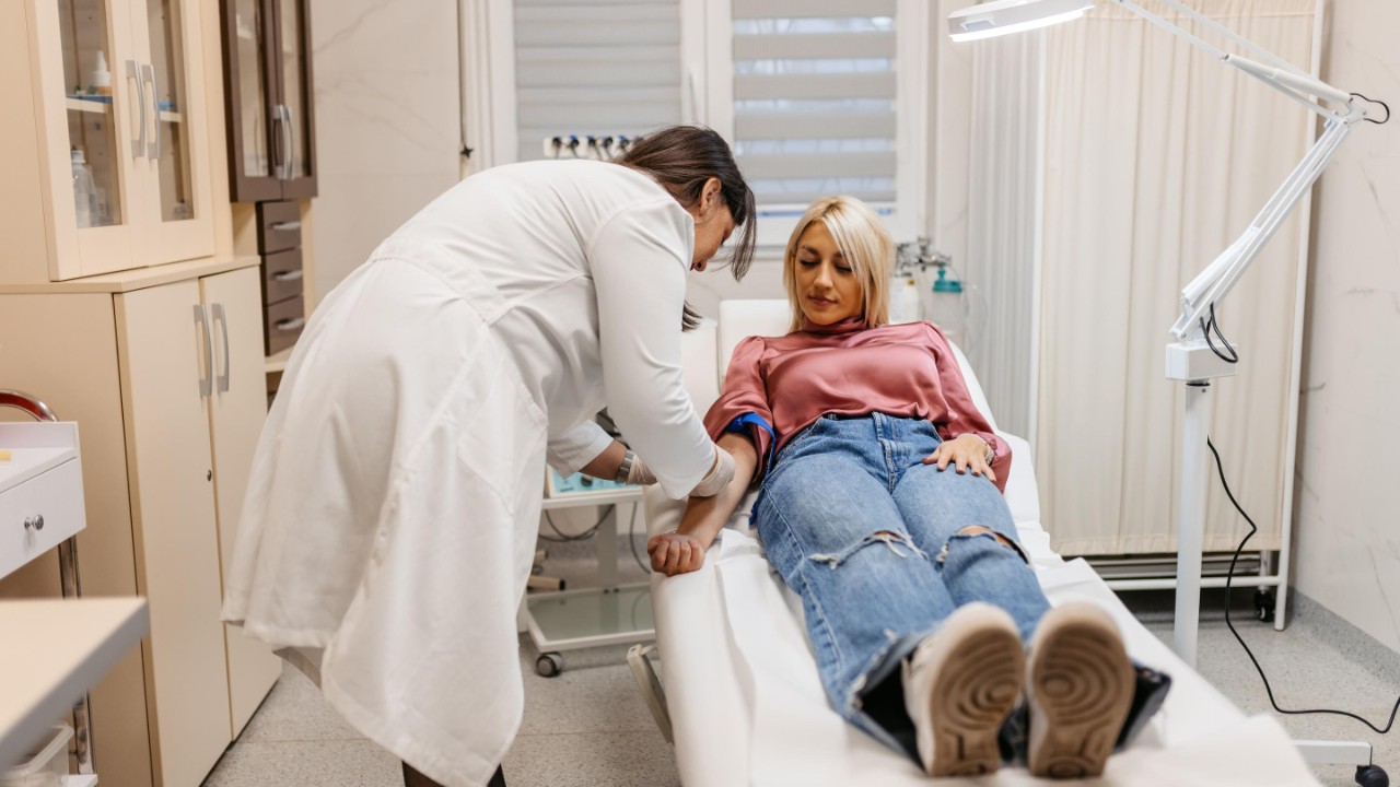 Female doctor taking blood samples from a female patient in a medical clinic