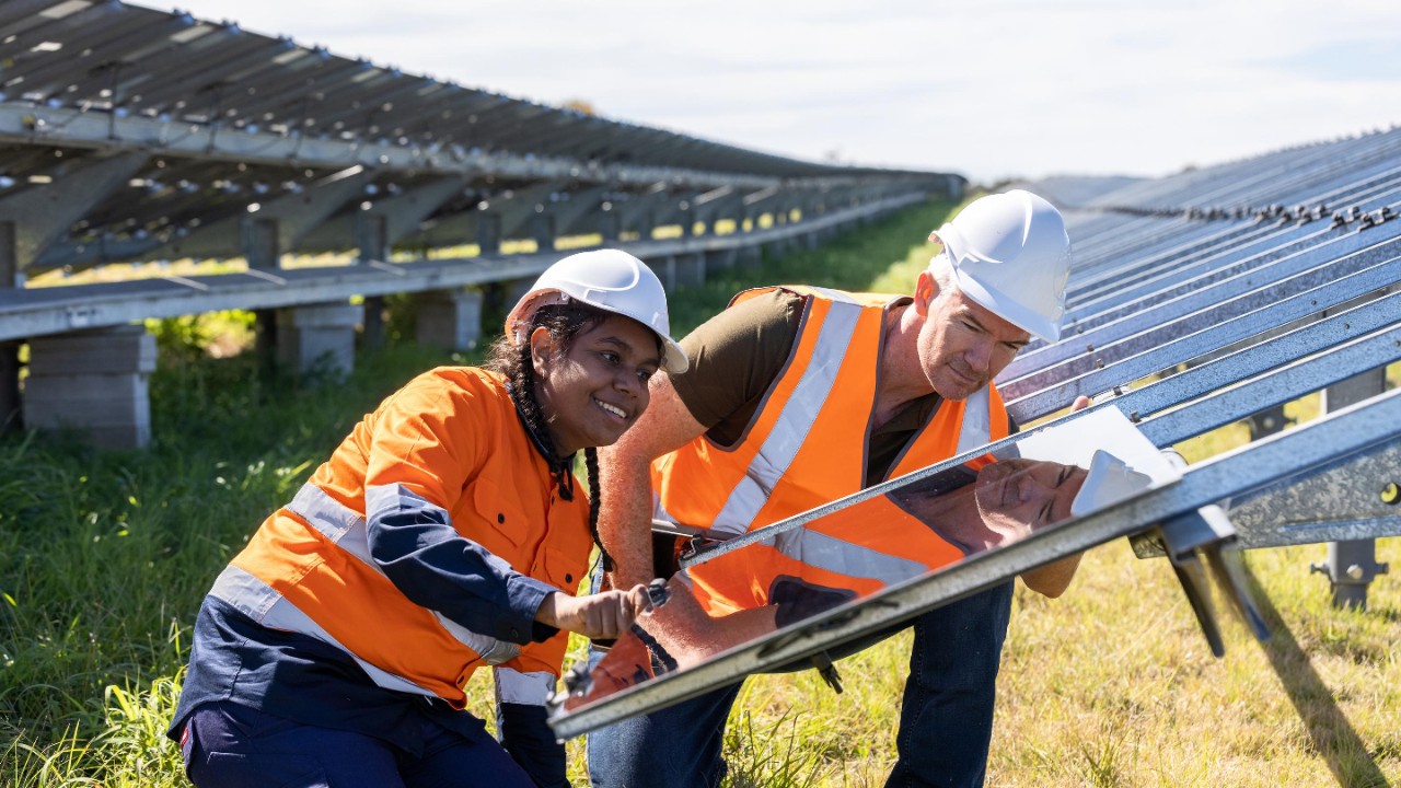 Senior Engineer and Aboriginal Australian Apprentice Working Together On Solar Farm Installation