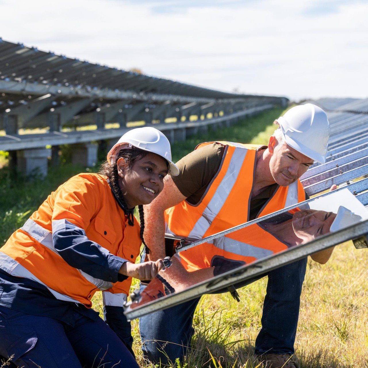 Senior Engineer and Aboriginal Australian Apprentice Working Together On Solar Farm Installation