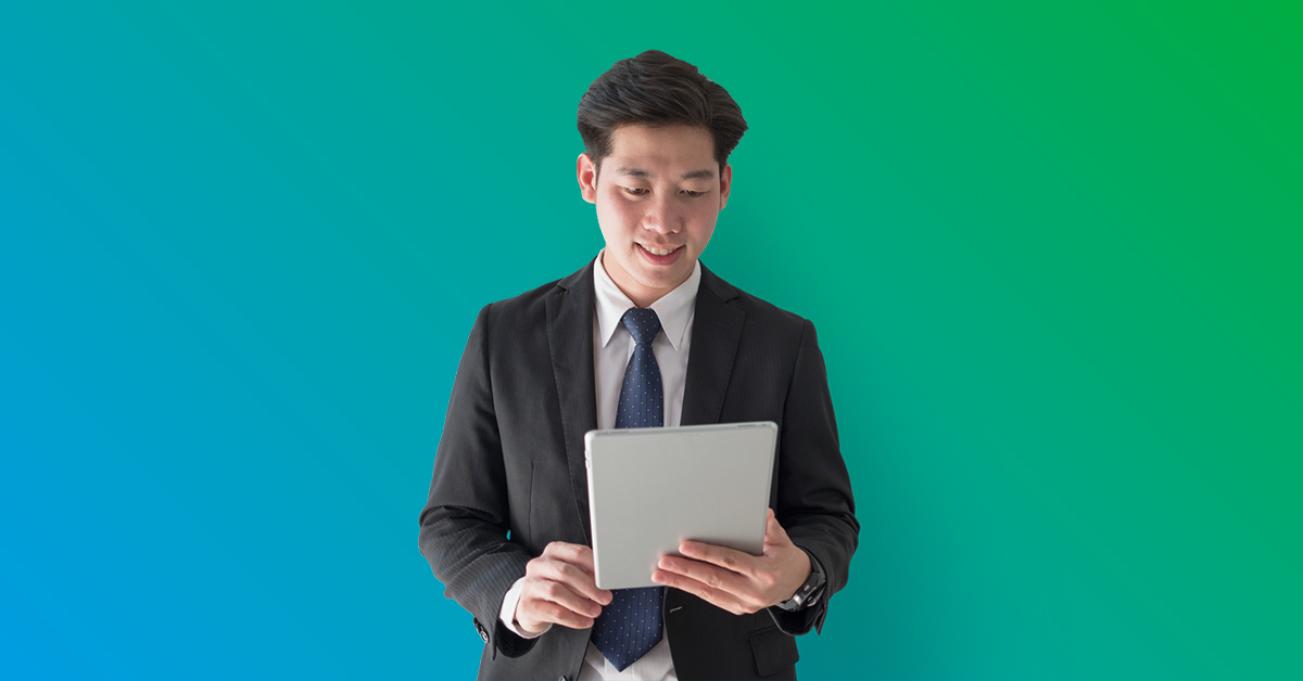 businessman in suit and tie happily looking at tablet