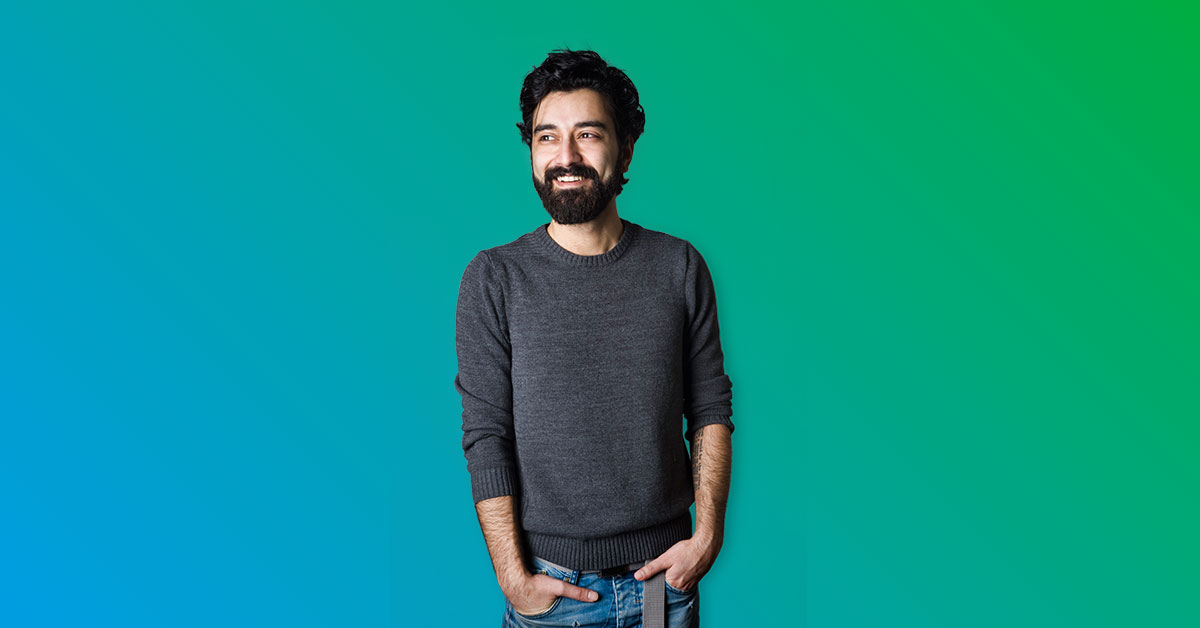 Smiling man standing with hand in pockets - blue to green gradient
