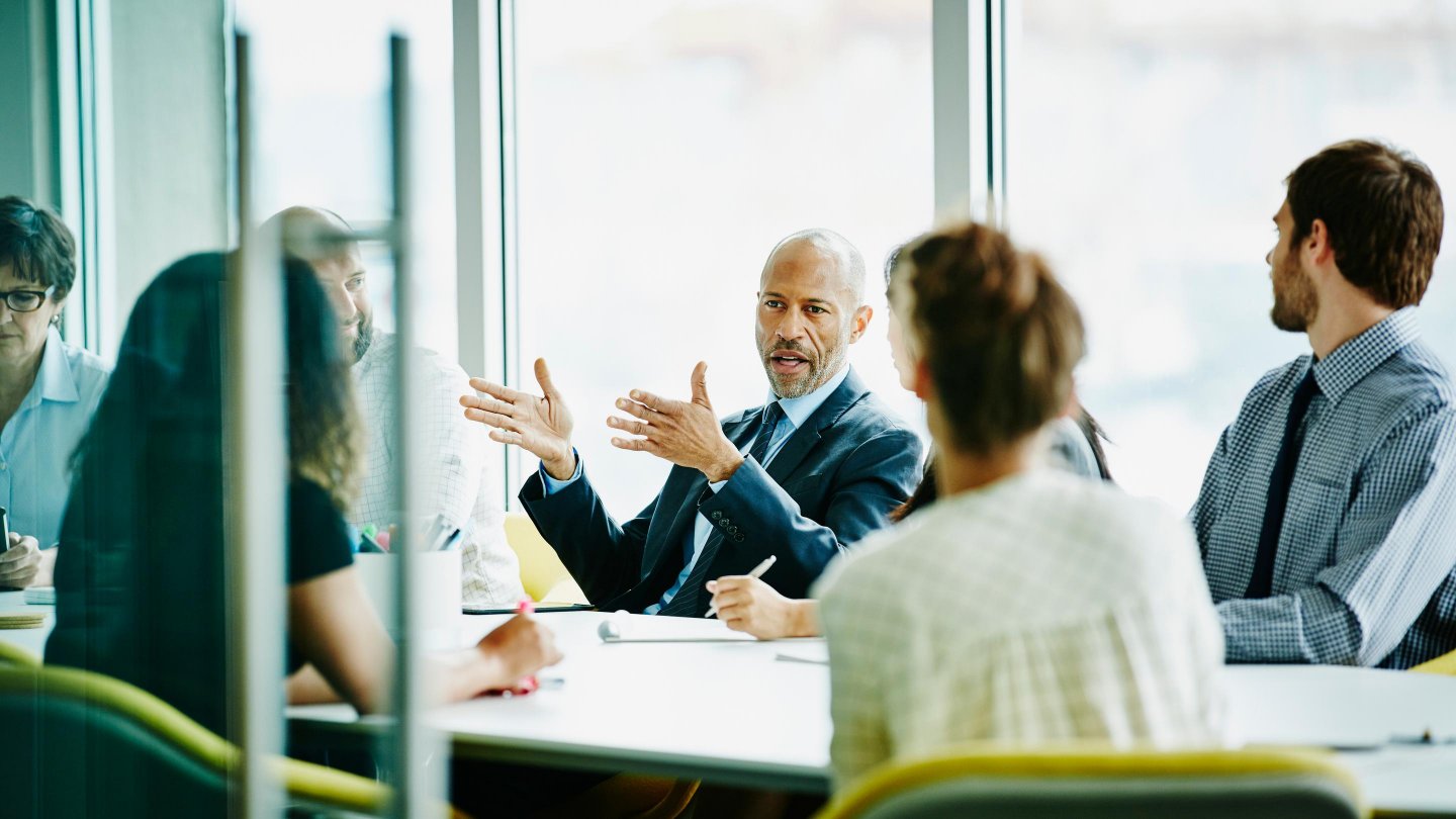  Mature businessman leading project meeting in office conference room