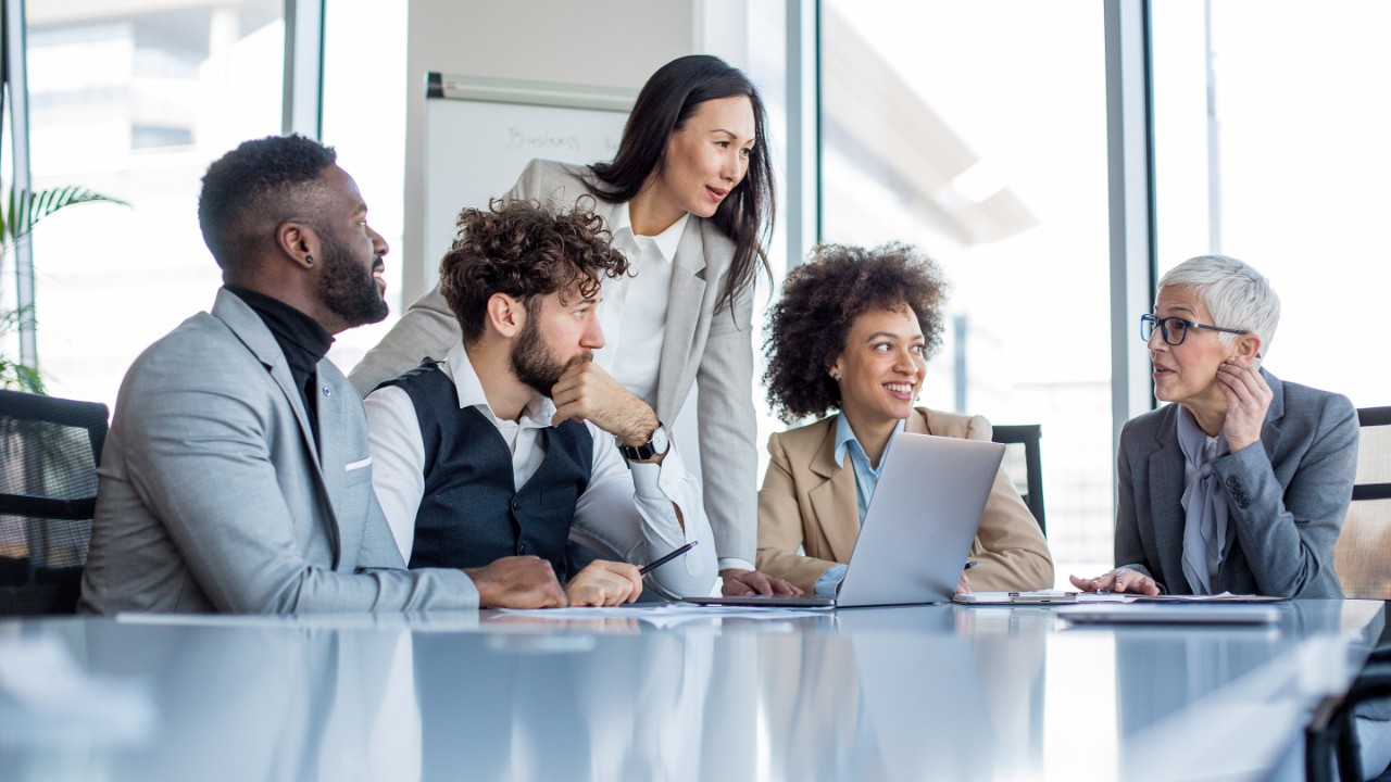 A mature CEO and her team of professionals having a briefing before the work.