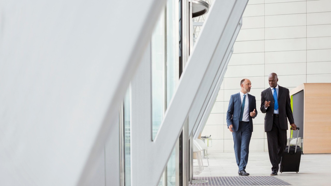 Businessmen walking with luggage at airport