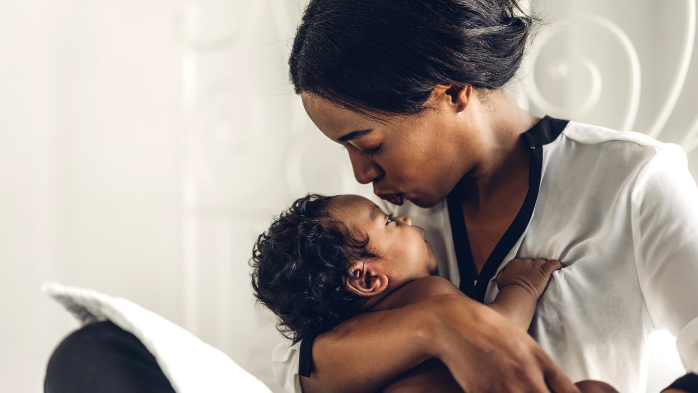 Portrait of enjoy happy love family african american mother playing with adorable little african american baby.Mom touching with cute son moments good time in a white bedroom.Love of black family concept
