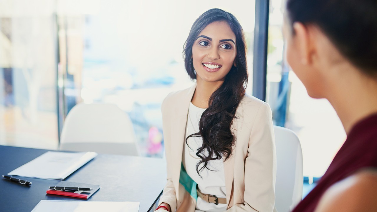Cropped shot of two young businesswoman talking while sitting in their office