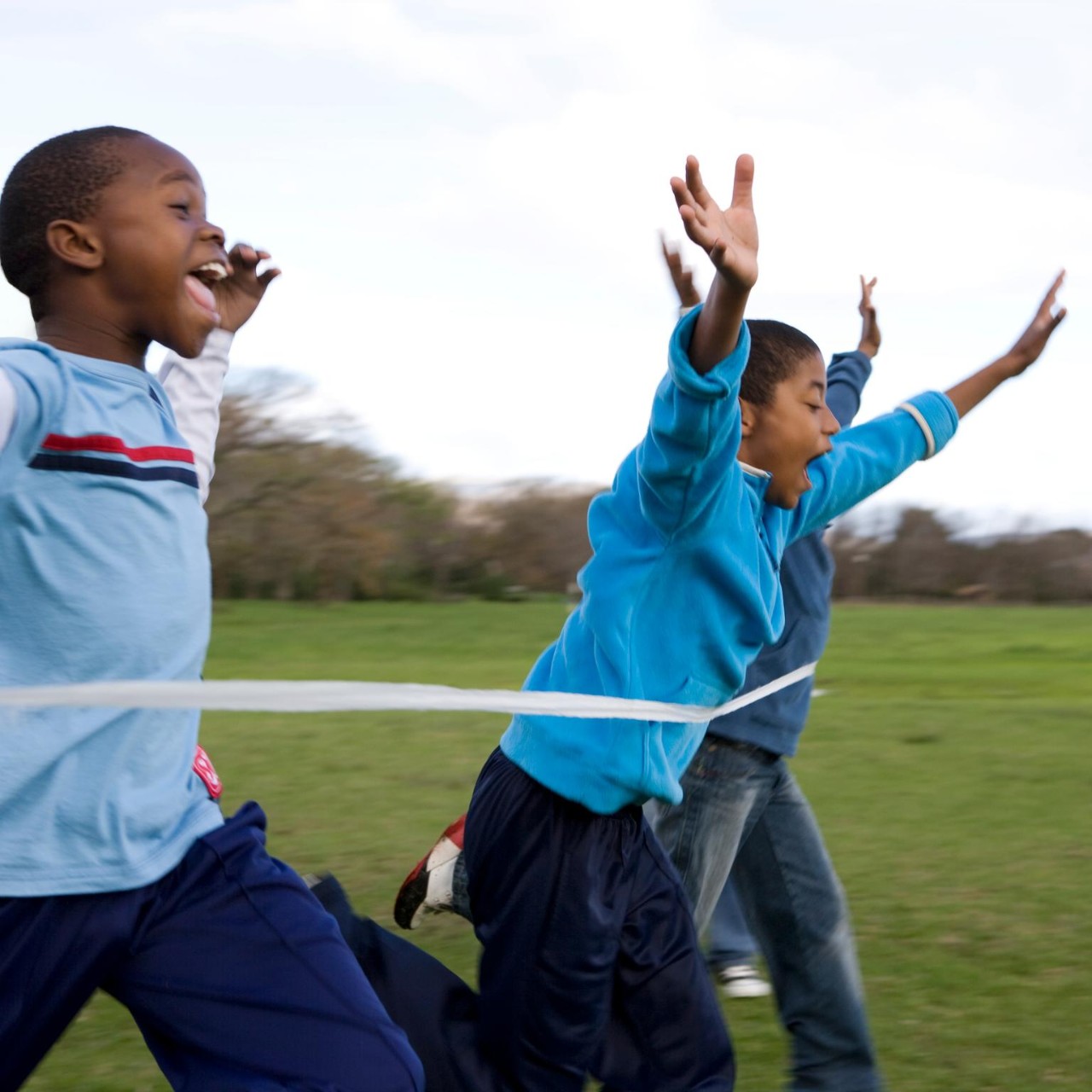Group of boys running through finishing line